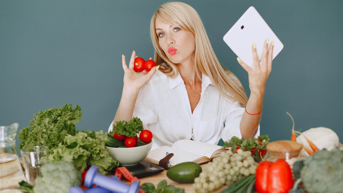 Vlogger promoting healthy eating with fresh vegetables on the table.
